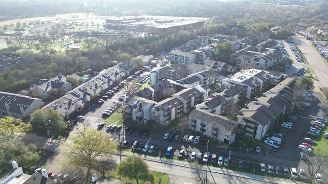 Apartments beside school fields near Fair Oaks Ave and Walnut Hill Ln overlook residential blocks adjoining athletic grounds and open green space. Pitched roofs, parked cars, winter trees, Dallas