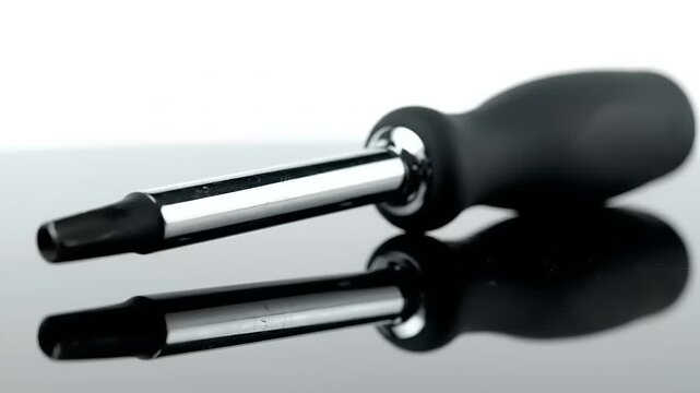 Double Ended Screwdriver on Reflective Surface.