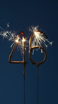 46 years celebration festive background made with Bengal fires in the form of number Forty six. Vertical video.