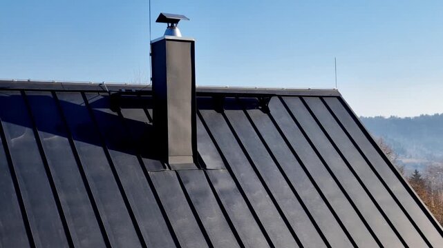  roof in anthracite color, shade RAL 7016. This type of roofing is very popular for its high durability, modern minimalist appearance, long service life, folded sheet metal, often aluminum or steel, 