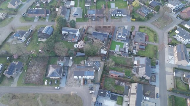 Aerial, strafe right, rightward slide Drone flight of Suburban Neighborhood with houses, gardens and streets. Urban planning, renewable energy. Solar panels. Rozendaal neighborhood in Diepenbeek, Belg