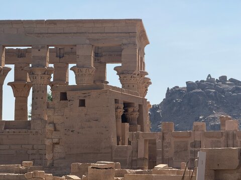 Majestic ancient Egyptian temple with colossal statues and intricate stone carvings under clear sky