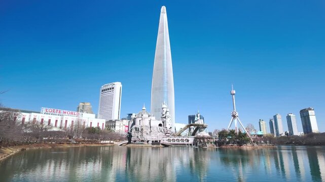 Seoul, South Korea - Mar. 07, 2026 : 4K  video of Korean People Relaxing at Songpa Naru Park by Seokchon Lake in Winter, View of Lotte World
