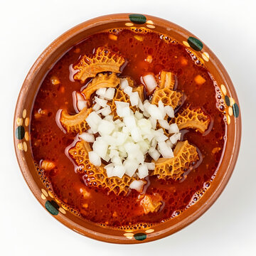 Delicious bowl of traditional Mexican menudo soup topped with chopped white onions