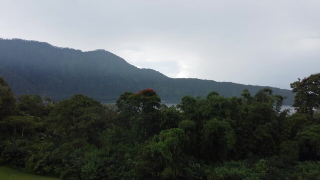 Cinematic aerial drone liftoff revealing Lake Beratan in the highlands of Bedugul, Bali, Indonesia.