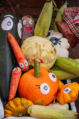 Obraz premium Colorful harvest display features playful painted vegetables with cheerful faces at local market event