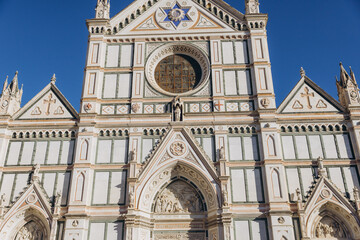 Obraz premium Basilica of Santa Croce facade in Florence, Italy, showcasing intricate Gothic architecture and religious art against a clear sky