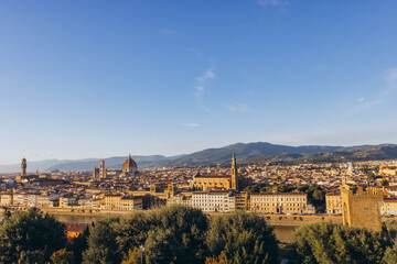 Obraz premium Florence skyline panoramic view with Duomo and historic buildings along Arno river under blue sky