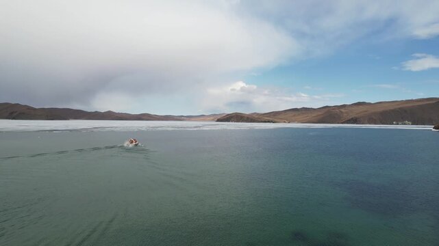 Lake Baikal in spring, ice drift in the lake. A hovercraft transports passengers to Olkhon Island 