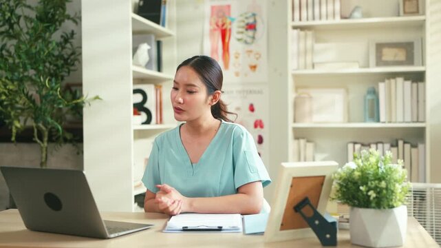 Female healthcare professional reviewing medical documents at desk with laptop in clinic office, administrative medical workflow, patient record management and modern healthcare documentation concept.