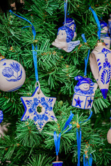 Obraz premium Colorful ceramic ornaments adorning a festive green Christmas tree for holiday celebrations