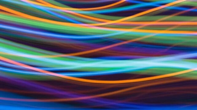 Vibrant multicolored wavy lines move rapidly across the screen in a mesmerizing abstract pattern.