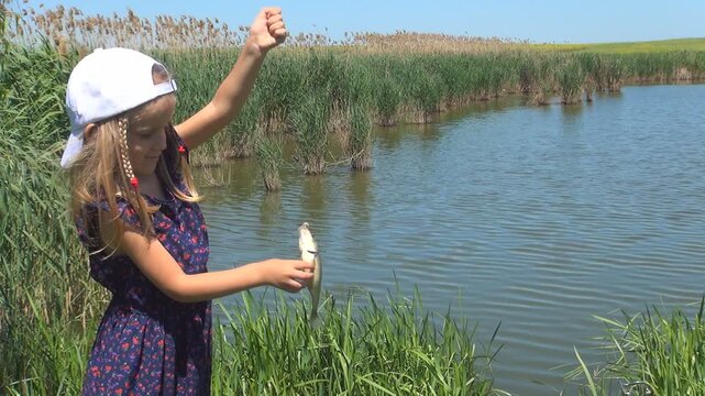 Child Studying a Fish Caught by Father, Girl Playing on a Fishing Lake, Children