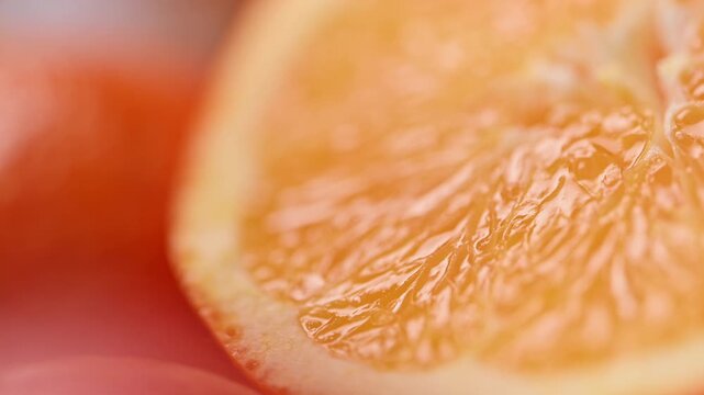 Macro shot of juicy orange slice with vibrant citrus pulp and natural juice shine. Fresh vitamin rich fruit texture with soft focus movement, summer refreshment concept for drinks and food advertising