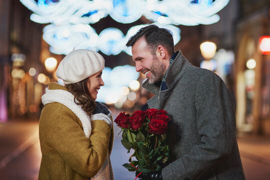 Man gifting his girlfriend bunch of red roses on Valentine's Day