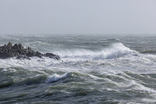 Turbulent stormy sea with jagged rocks