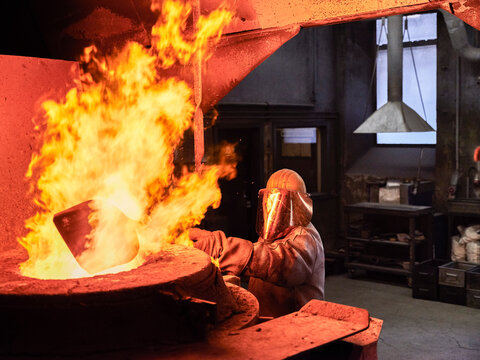Industry, worker at furnace during melting copper, wearing a fire proximity suit