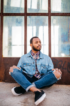 Portrait of serious young man sitting on the ground
