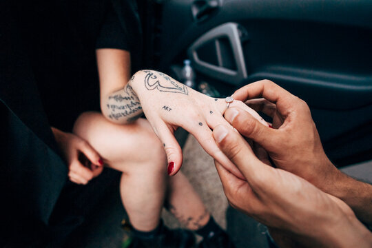 Close-up of boyfriend wearing engagement ring to girlfriend