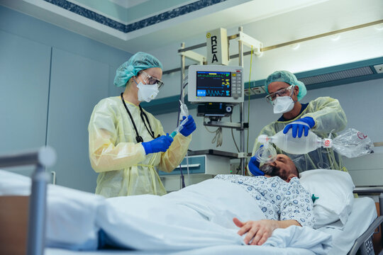Doctors with bag valve mask caring for patient in emergency care unit of a hospital