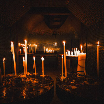 Lit votive candles in a dark church