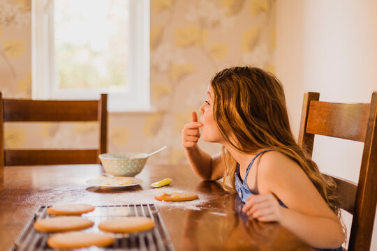 Girl decorating biscuits at home