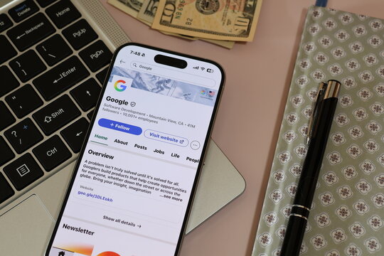 Kiel, Germany - 03-06-2026: US technology company Google LLC Profile on LinkedIn Displayed on a Smartphone ontop of Laptop