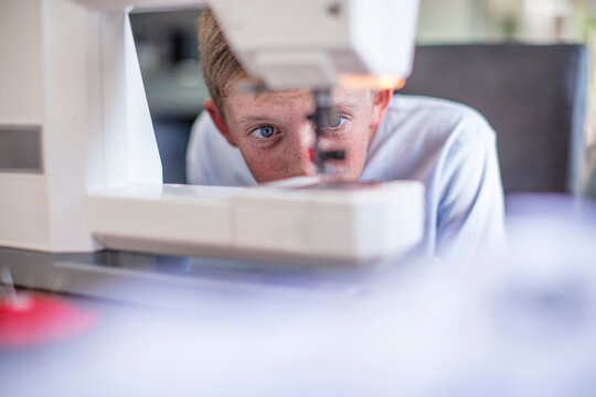 Boy examining sewing machine