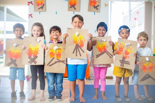 Portrait of smiling children presenting images of fire in kindergarten