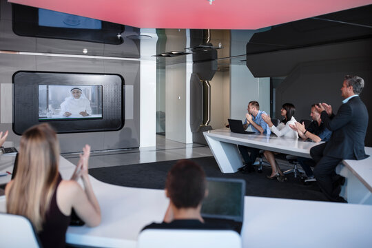 Business people applauding international customers in video conference