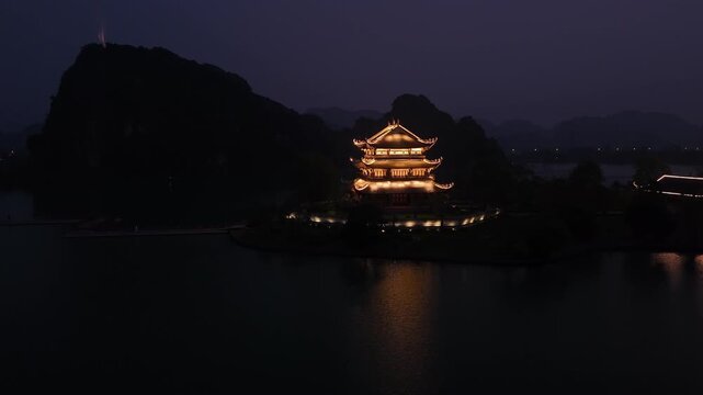 Buddhist pagoda on a lake in hoa lu ancient capital, ninh binh, vietnam reflecting in the water at night