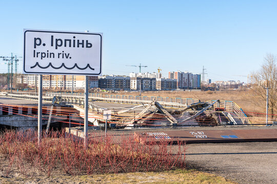 Irpin, Ukraine - 07 March 2026: View of the destroyed Irpin Bridge, a scene of devastation with twisted metal against a backdrop of distant buildings.