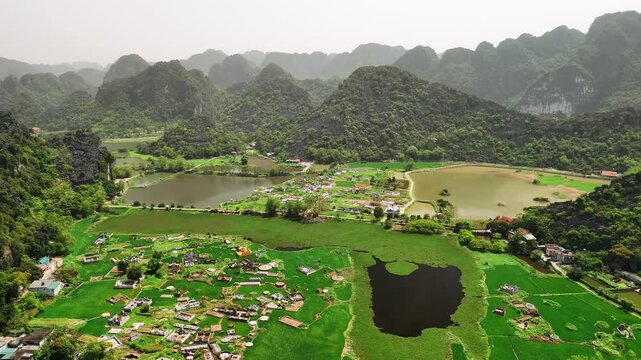 Aerial view of hoa lu ancient capital in ninh binh with its rice fields, mountains, and village in a spectacular valley