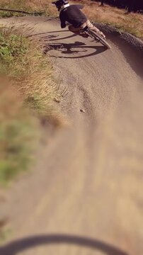 Kids having fun driving downhill MTB mountainbike on sunny day - vertical video