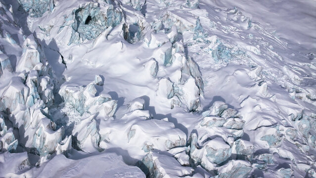 Aerial view of a frozen landscape where icy peaks and snow-covered valleys carve a stark, beautiful tableau, Chamonix-Mont-Blanc, Auvergne-Rhone-Alpes, France.
