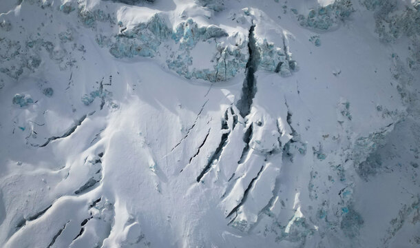 Aerial view of the stark white Vallee Blanche Glacier, scored with deep blue crevasses under a cold, crisp sky, Chamonix-Mont-Blanc, Auvergne-Rhone-Alpes, France.