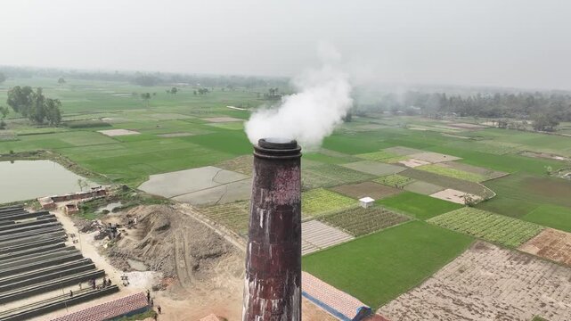 Brick kiln chimney emitting thick smoke into the air