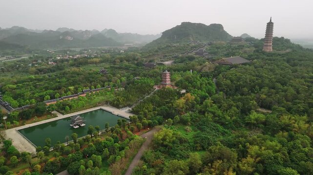 Aerial view of bai dinh pagoda complex with pagodas and temples surrounded by lush green mountains in ninh binh, vietnam