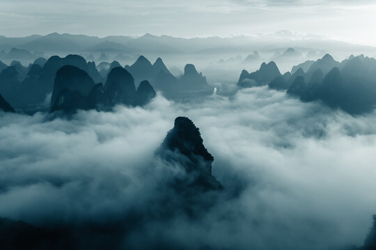 Aerial view of karst peaks piercing through ethereal clouds, Guilin, China.
