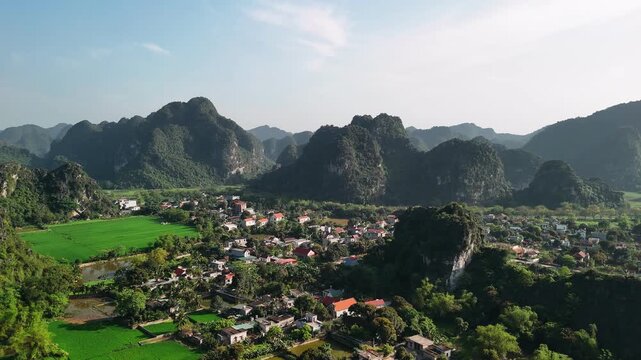 Aerial view of hoa lu village in ninh binh province vietnam with limestone mountains and green rice paddies on a sunny day