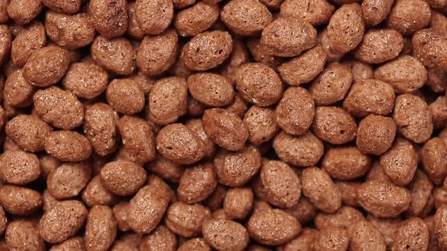 Slowly rotating pile of chocolate cereal balls. Top view shot