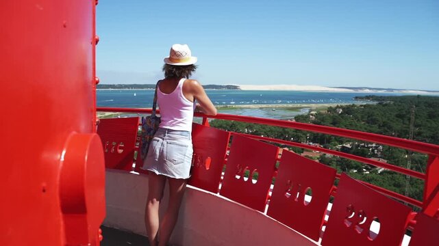 Bassin d'Arcachon, Gironde, Nouvelle-Aquitaine, France, une personne en haut du phare du cap ferret regarde la dune du pilat au loin