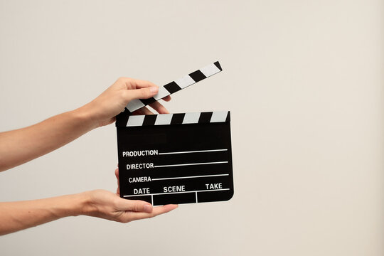Hands holding clapperboard, signaling action on film set for movie a scene production, directing