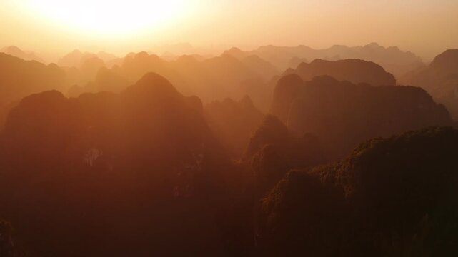Aerial view of golden sunset over the mountains of ninh binh province in vietnam, creating a stunning layered scenic landscape