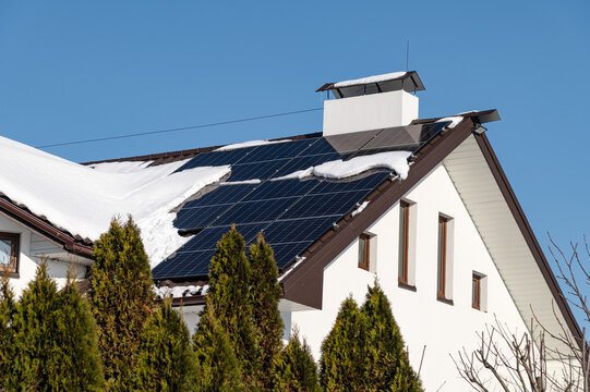 Winter scene with solar panels on a roof, showing safety measures against snow and ice