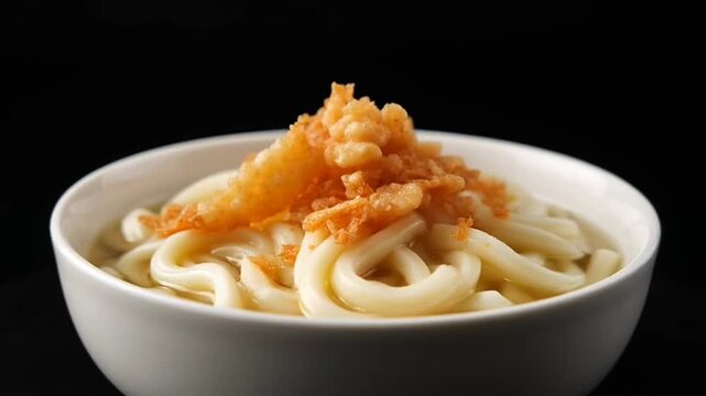Udon Delight: A captivating photo of a steaming bowl of udon noodles, perfectly complemented by golden tempura, offers a delicious culinary experience.