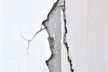 Obraz premium cracked concrete column corner with damaged plaster and structural failure