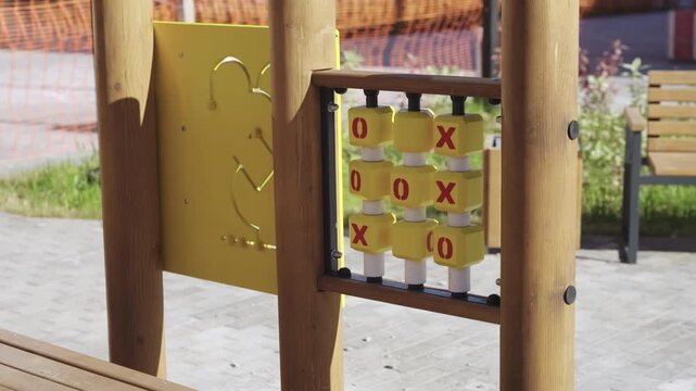 Bead maze and tic tac toe on children playground in city park. Skills and thinking development toys for little kids in apartment yard