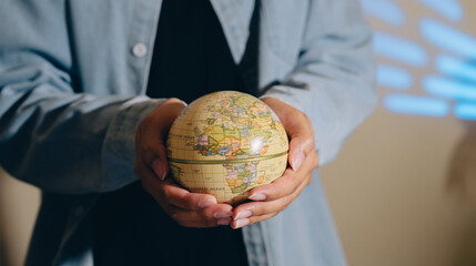 Person holding small globe in hands world map geography concept travel planning education global connection exploration discovery curiosity learning © JK_kyoto