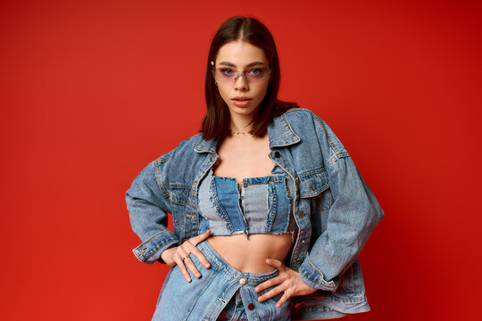 Stylish young woman showcases denim fashion in a vibrant studio setting